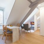 Salon-cosy-et-lumineux-avec-vue-sur-les-toits-et-montagnes-le-perchoir-d-etigny-min